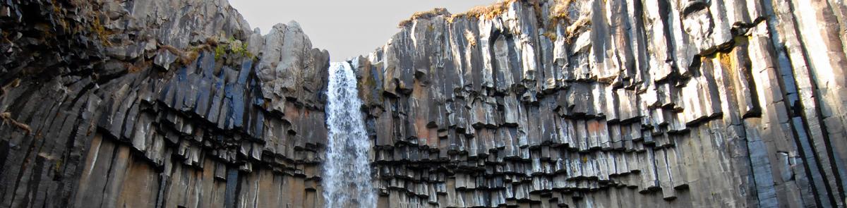 waterfall through rocky cliff