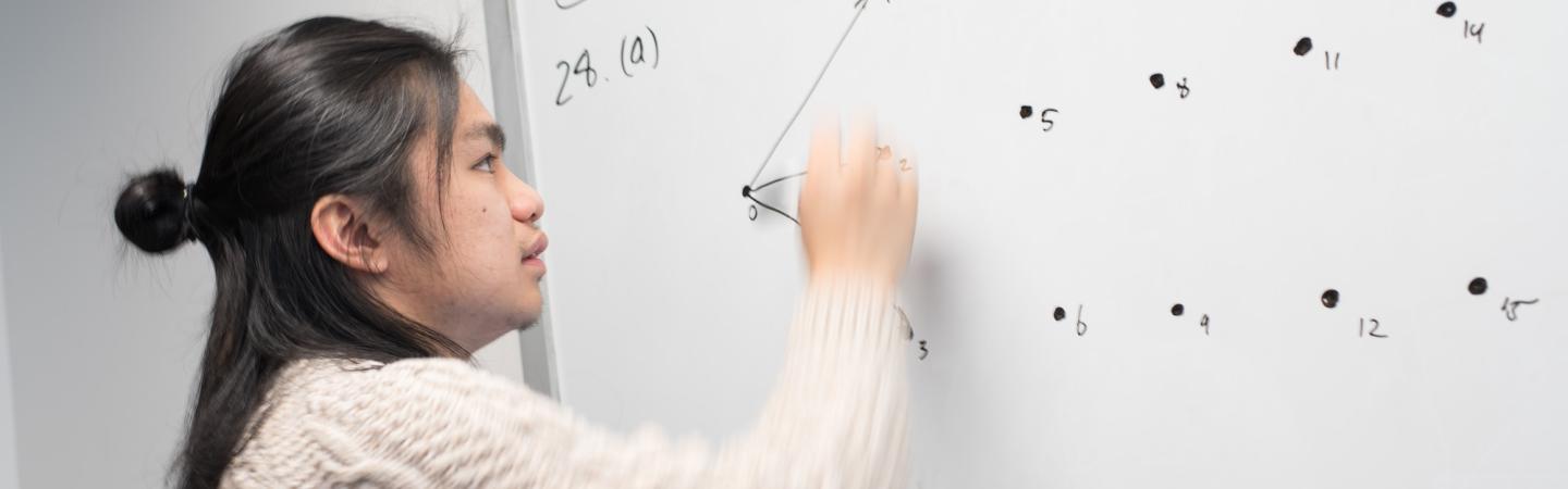 student doing math on a whiteboard