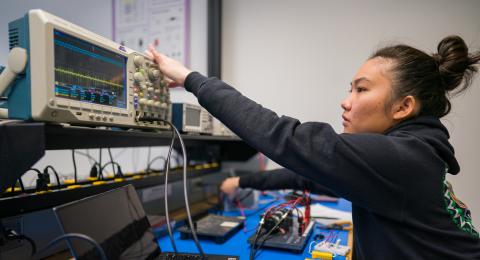 Computer Engineering student in the lab working on electronics