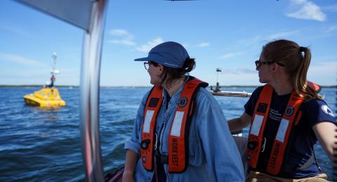 2 students on a boat looking behind them