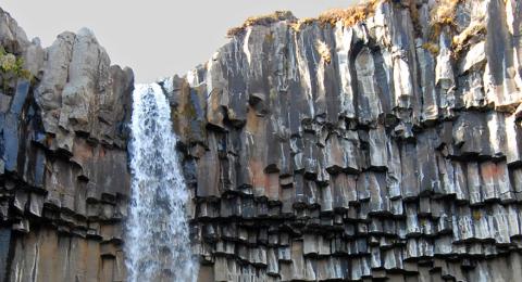 waterfall through rocky cliff