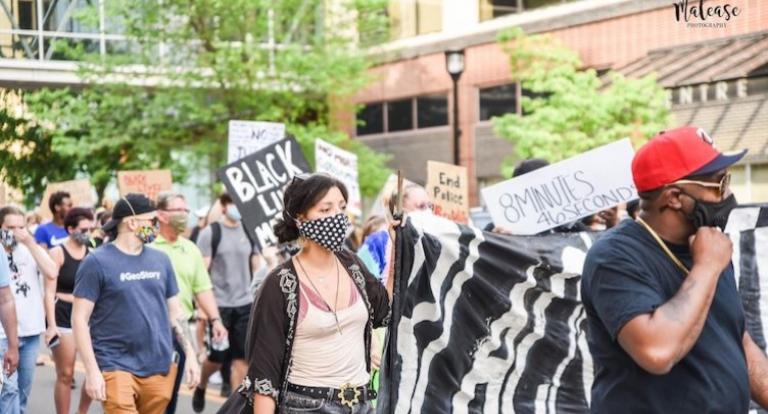 Tamara Marcus holds one side of BLM banner