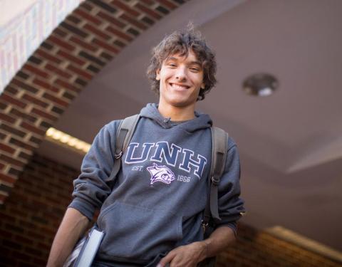 undergraduate student in front of campus building