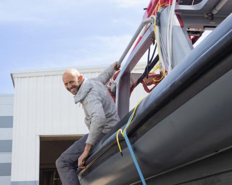 Exail Employee Hanging onto the Surface Vessel; Smiling
