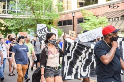 Tamara Marcus holds one side of BLM banner
