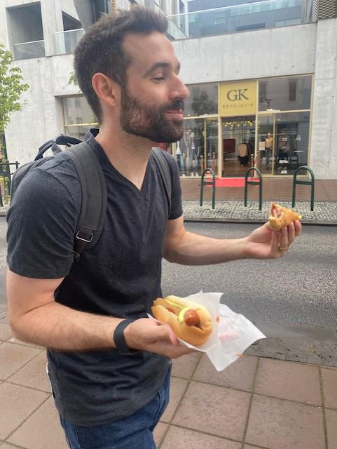 John enjoying two Icelandic style hot dogs in Reykjavík.